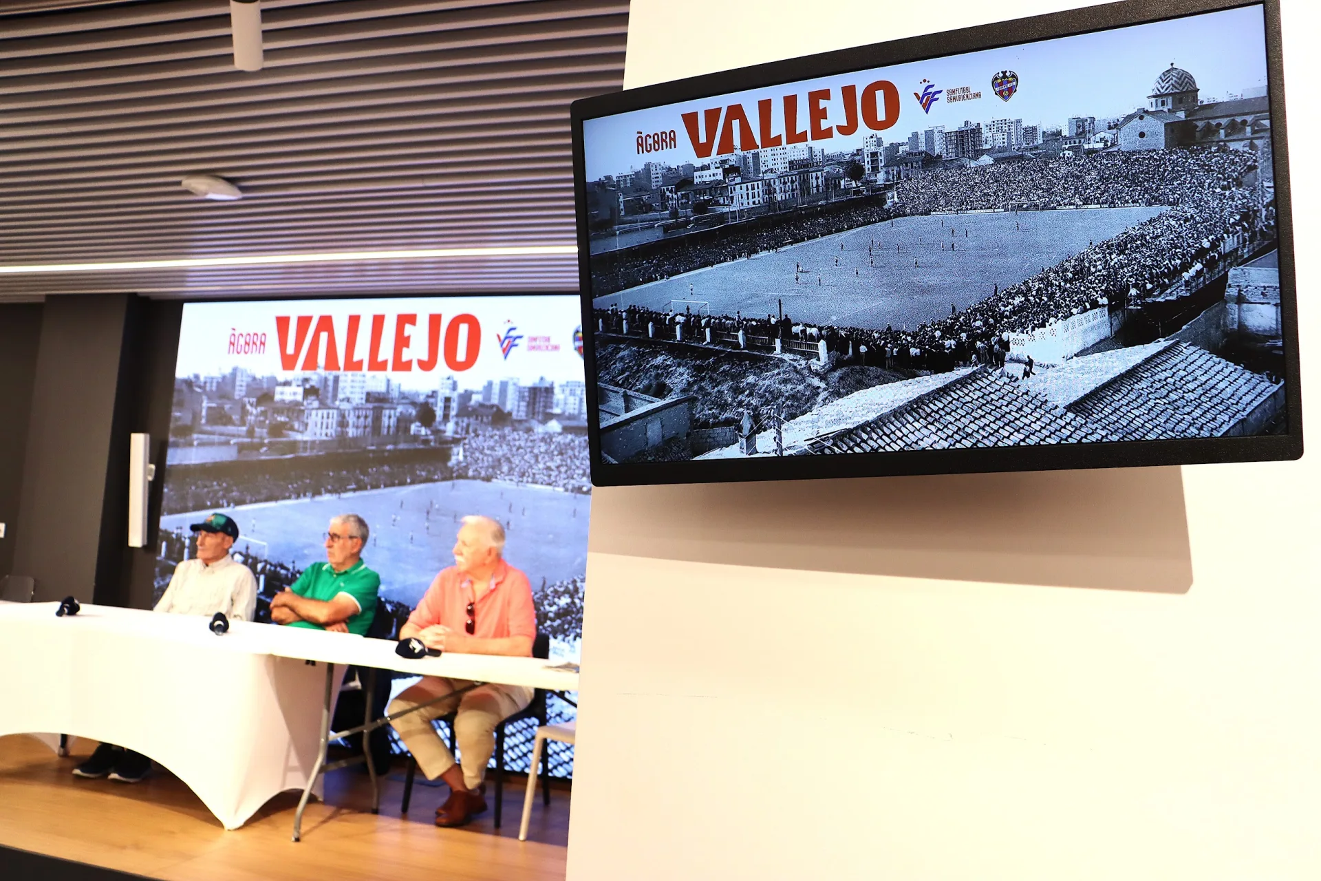 Mesa de protagonistes de l'acte Portal de Vallejo del Levante UD amb una imatge de l'antic estadi de Vallejo