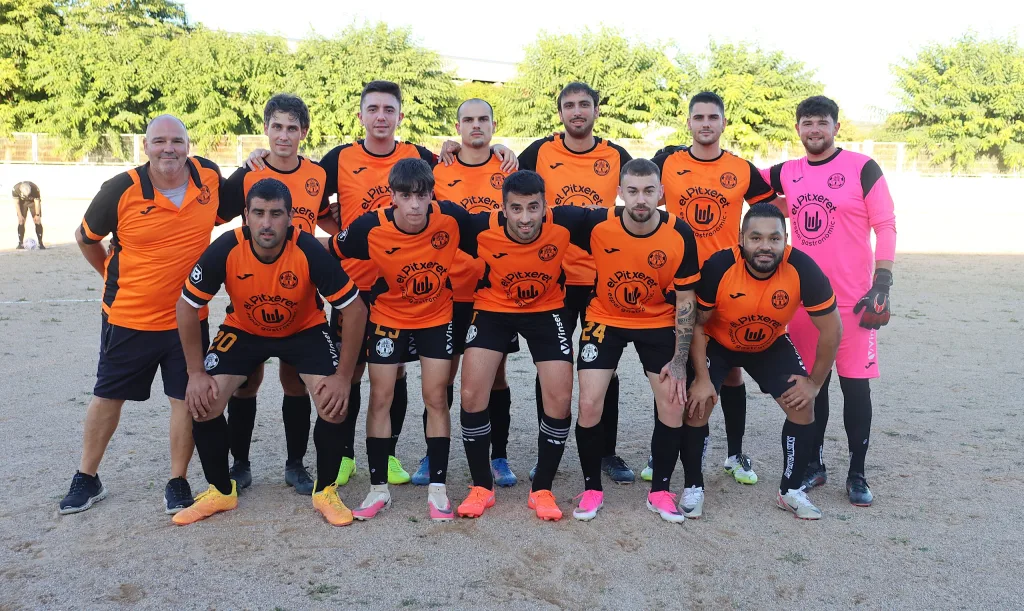 Once inicial del Quatretonda CF, de naranja, posando antes del partido ante el CD Albaidense en Tercera FFCV
