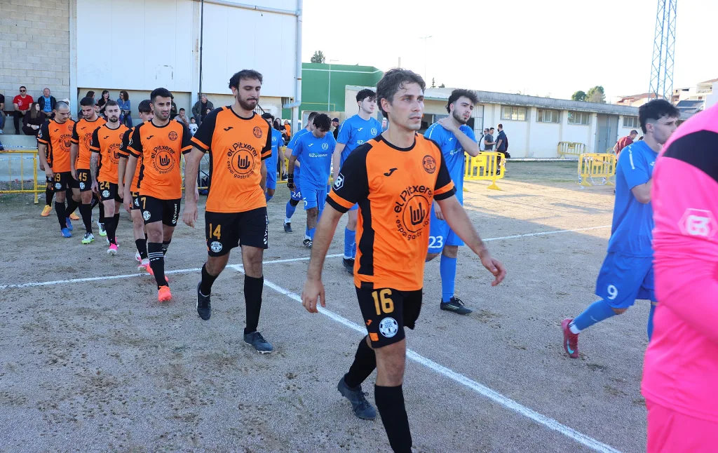 Los jugadores del Quatretonda CF y del CD Albaidense salen al campo de tierra de Quatretonda, Tercera FFCV