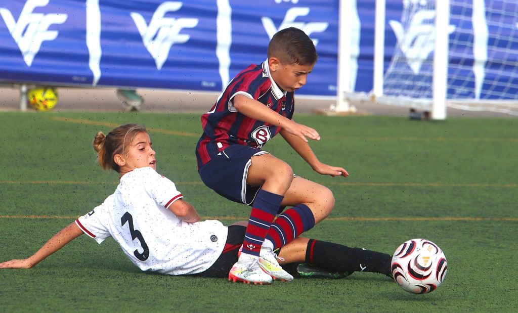 Un jugador del Levante UD i un rival disputen el baló en el II Torneig Tornem! de Manises